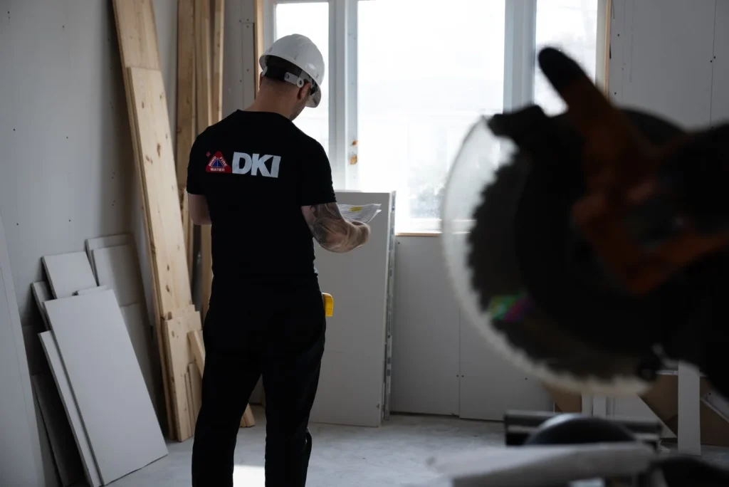Technician using moisture meter on floorboards